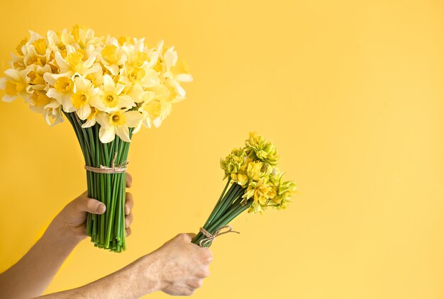 Mannelijke handen als achtergrond met een boeket van bloemen.