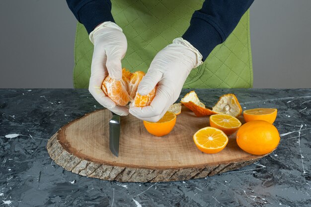 Mannelijke handen met sappige mandarijn op marmeren tafel.