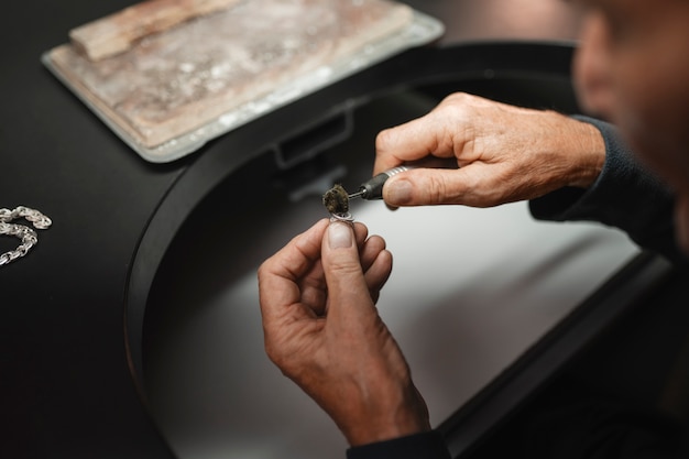 Gratis foto mannelijke juwelier werkzaam in de winkel