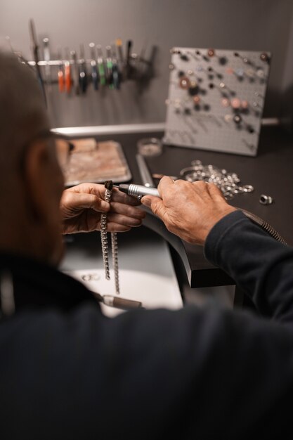 Gratis foto mannelijke juwelier werkzaam in de winkel