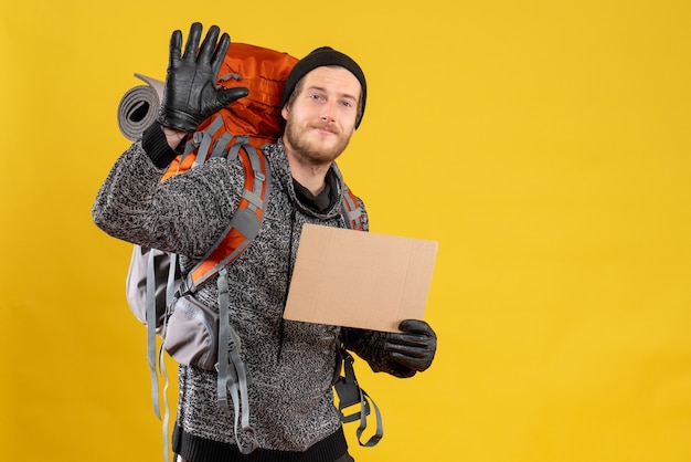 mannelijke lifter met leren handschoenen en rugzak met lege kartonnen wuivende hand