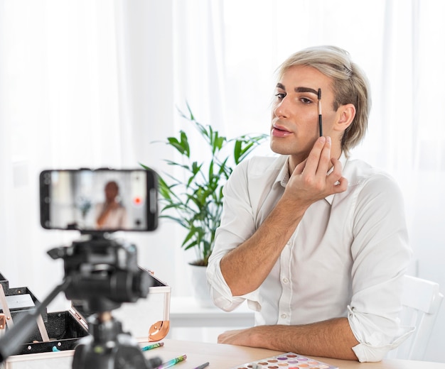 Mannelijke make-up kijkt een video maken met een mobiele telefoon