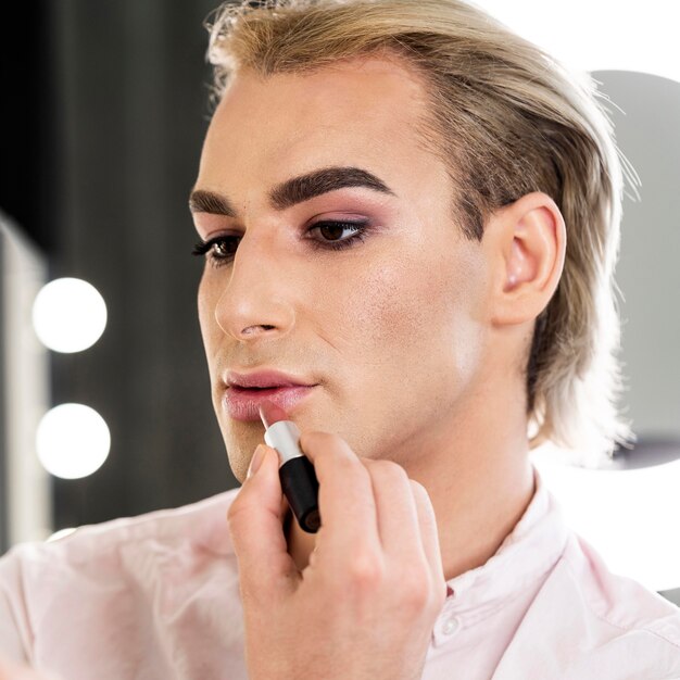 Mannelijke make-up kijkt met lippenstift
