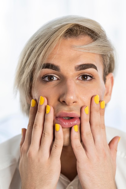 Mannelijke make-uplook en gele nagels