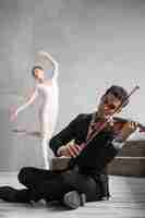Gratis foto mannelijke muzikant viool spelen en intreepupil ballerina dansen
