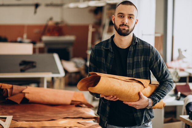 Mannelijke ontwerper en leerkleermaker die in een fabriek werken