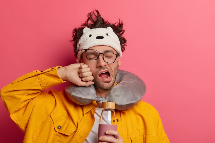 Gratis Foto mannelijke passagier draagt een opgeblazen reiskussen over de nek en een schattig oogmasker