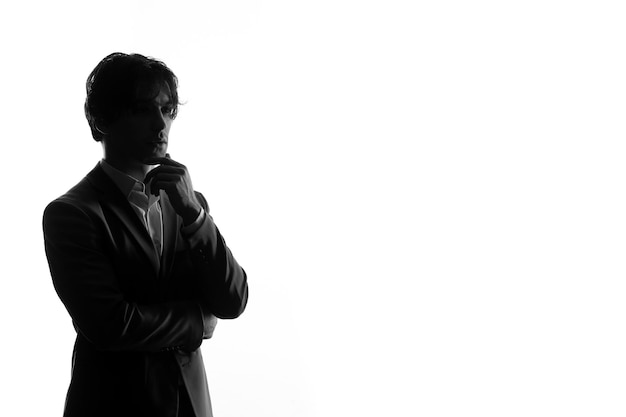 Gratis foto mannelijke persoon silhouet in strikt pak op zoek gestrest witte achtergrond young