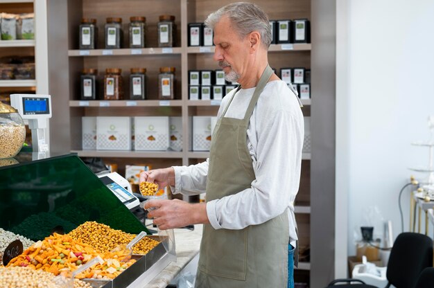 Mannelijke producer in zijn winkel met verschillende goodies