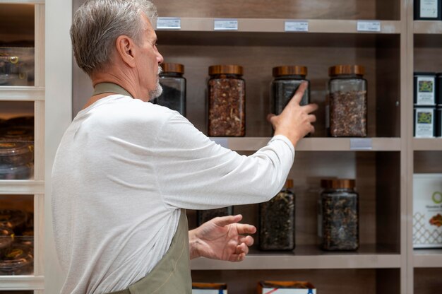 Mannelijke producer in zijn winkel met verschillende goodies