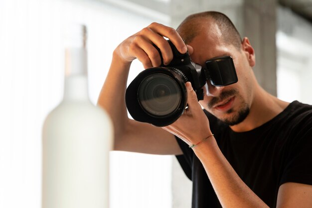 Mannelijke productfotograaf doet zijn werk in de studio