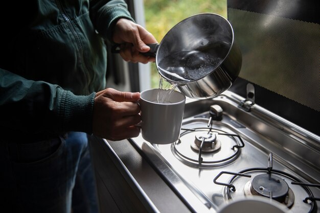 Mannelijke reiziger die zijn koffie maakt in een busje