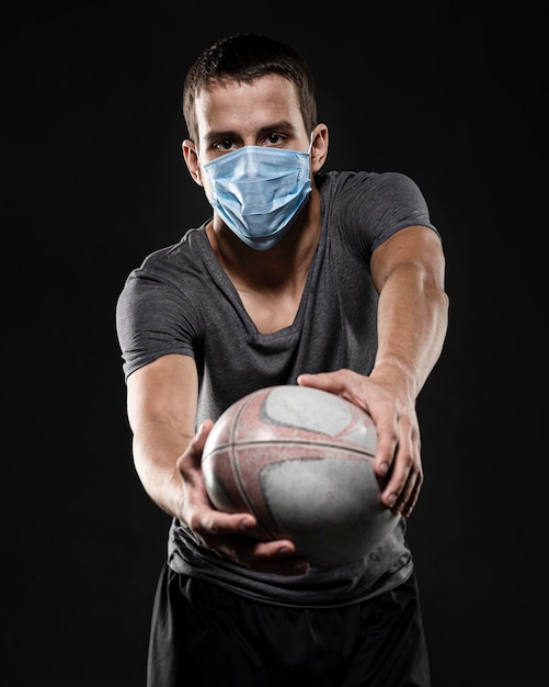 Mannelijke rugbyspeler met de medische bal van de maskerholding
