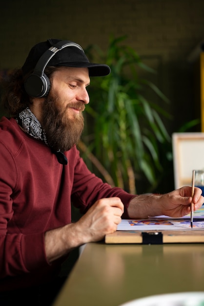 Mannelijke schilder in de studio met waterverf op zijn kunst