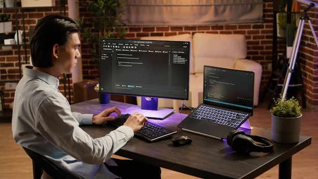 Mannelijke systeemhacker codering beveiligingsprogramma op pc-software, firewallgegevens programmeren op coderingsserver. computer gebruiken om applicatiescript te coderen op het display. .