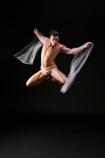 Gratis foto mannelijke turner die in lucht springt