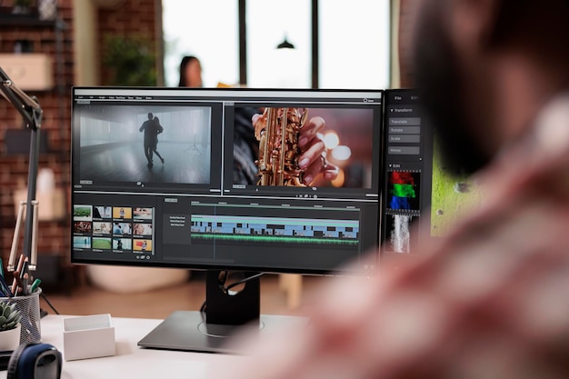 Mannelijke videograaf die videomontage bewerkt op postproductiesoftware, die op de computer werkt. Filminhoud maken met kleurcorrectie, creatieve multimediafilmopnamen bewerken in de app.