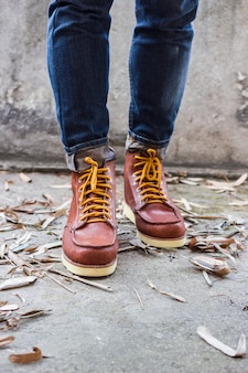 Mannelijke voet met bruine lederen schoenen en jeans