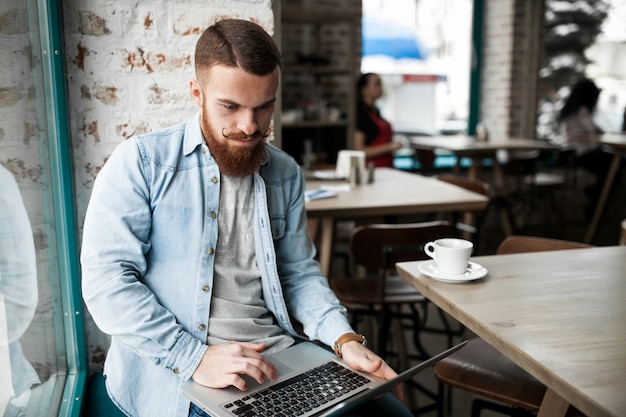 Mannelijke volwassene die mensen online studeert