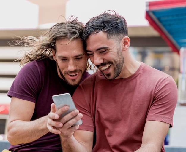 Mannelijke vrienden zitten en kijken op mobiel