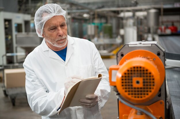 Mannelijke werknemer inspecteren machines in koude drank fabriek
