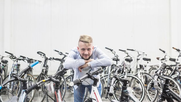 Mannelijke werktuigkundige die op fiets in workshop leunt