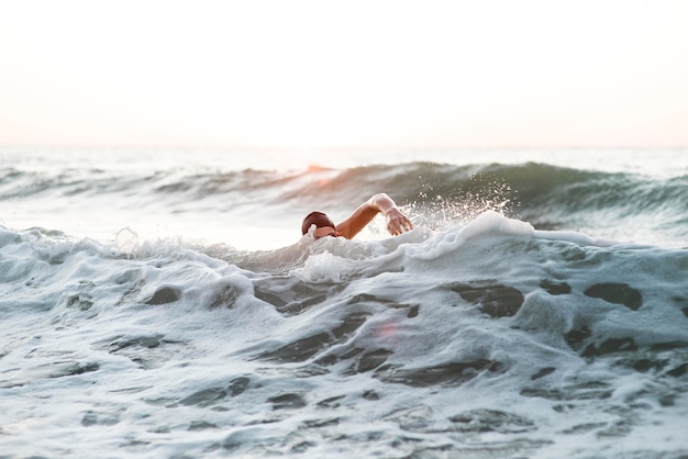 Gratis foto mannelijke zwemmer die in de oceaan zwemt