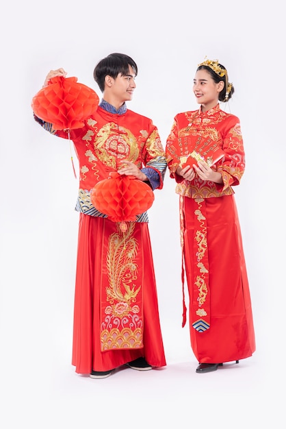 Mannen en vrouwen dragen cheongsam die glimlachen om te krijgen - krijg met een mooie rode lamp en cadeaugeld