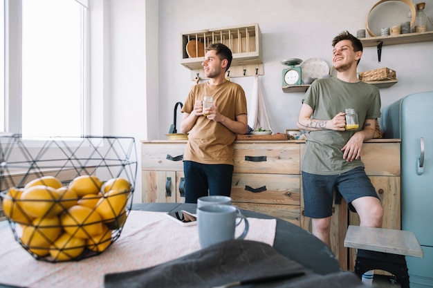 Mannen houden potje sap kijkt uit raam