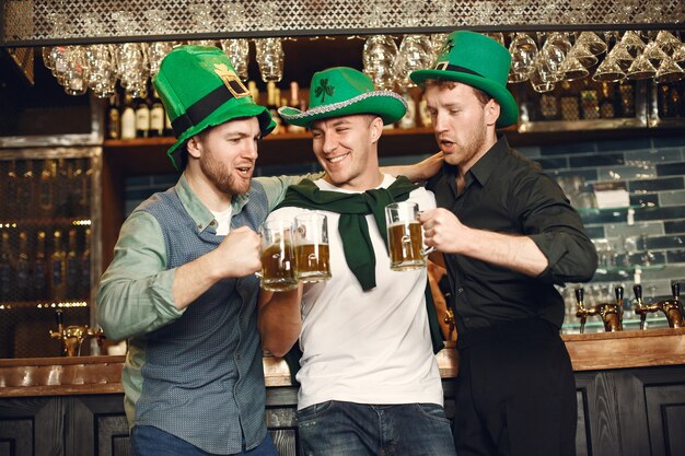 Mannen in groene hoeden. Vrienden vieren St. Patrick's Day. Viering in een pub.