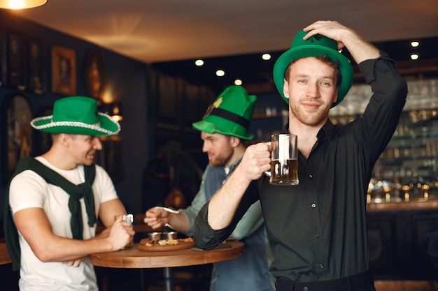 Mannen in groene hoeden. vrienden vieren st. patrick's day. viering in een pub.