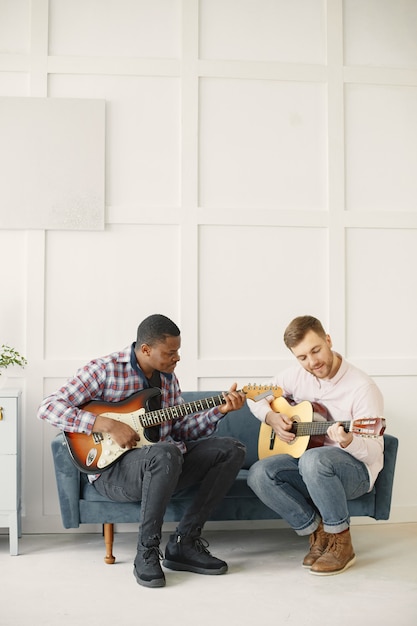 Mannen spelen gitaar. muziek schrijven. afrikaanse en blanke mannen.