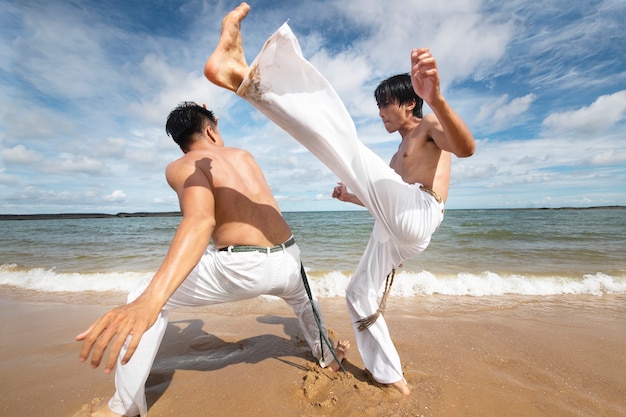 Gratis foto mannen trainen voor capoeira op het strand
