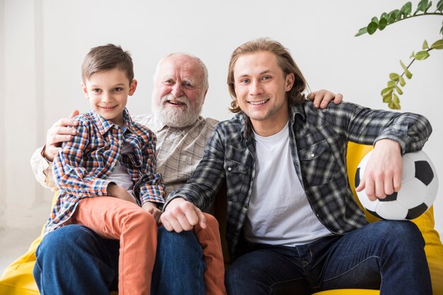 Mannen van verschillende generaties kijken tv op de bank