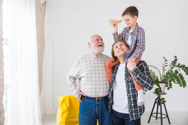 Mannen van verschillende generaties staan samen lachend tijdens het spelen