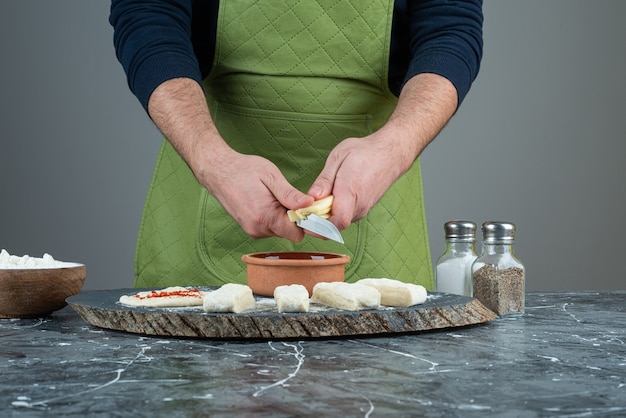 Mannenhand in handschoenen deeg maken op marmeren tafel.