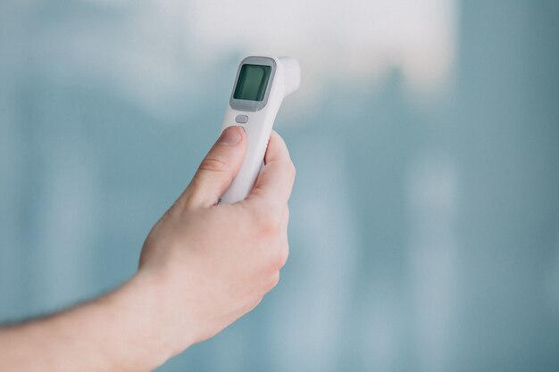 Mannenhand met electro thermometer