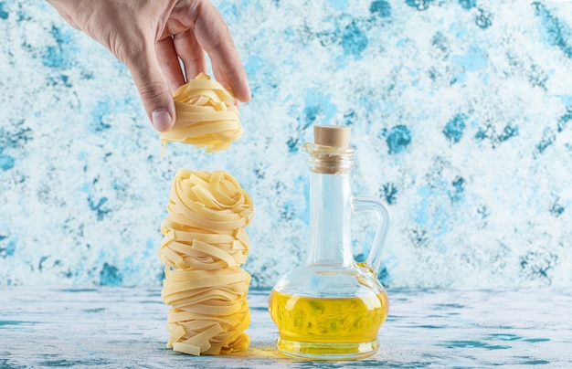 Gratis foto mannenhand nemen pasta nest van blauw.