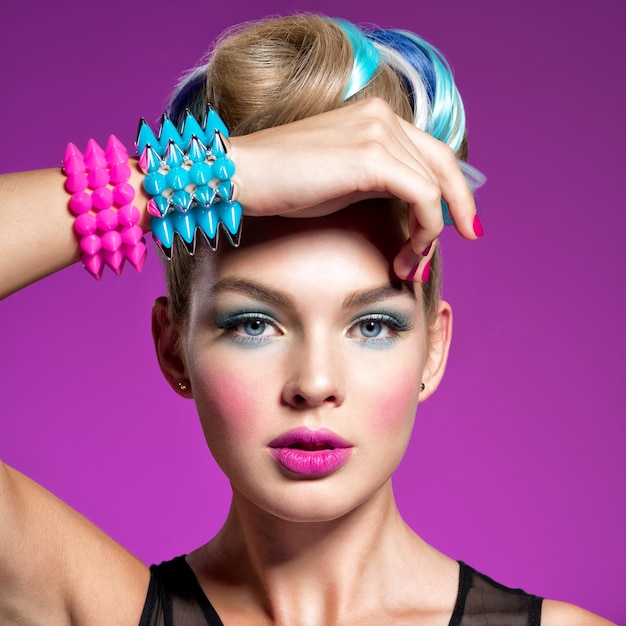 Gratis foto mannequin met lichte make-up en creatief kapsel vrouw met maniermake-up close-upportret