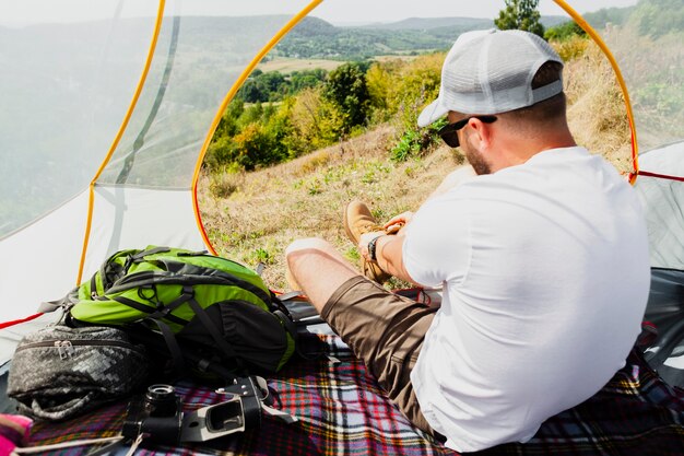 Mannetje dat in tent zijn schoenen aantrekt