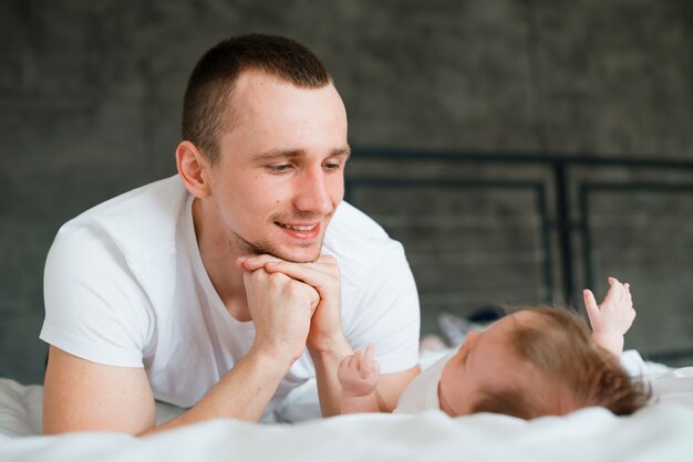 Mannetje dat op vuist leunt terwijl het liggen met baby