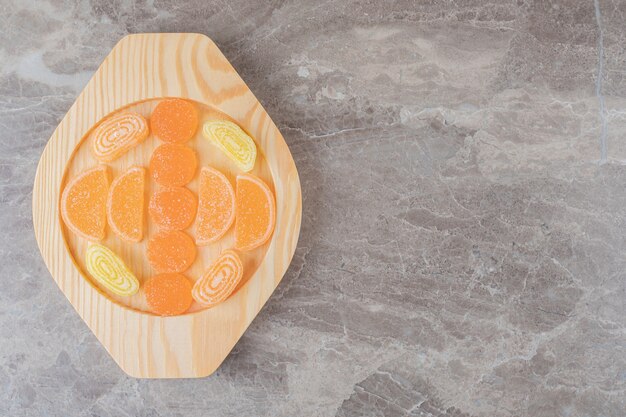 Marmeladebundel op een houten schaal op marmeren ondergrond