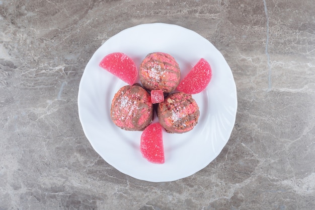 Marmelades en kleine cakes op een schaal op een marmeren oppervlak