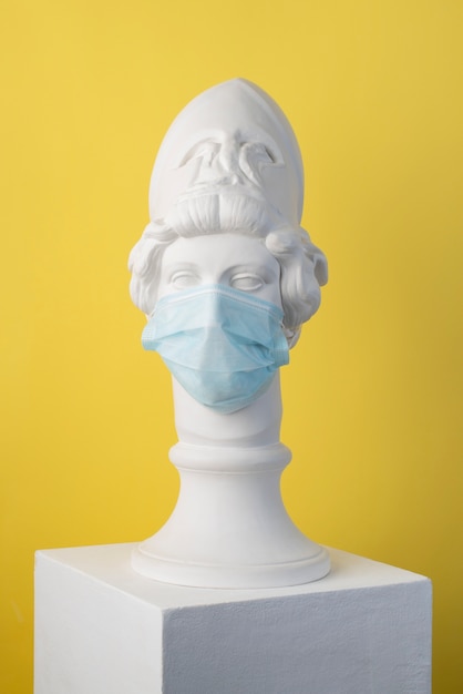 Marmeren sculptuur van historische figuur met medisch masker