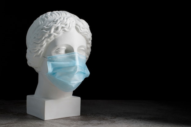 Marmeren sculptuur van historische figuur met medisch masker