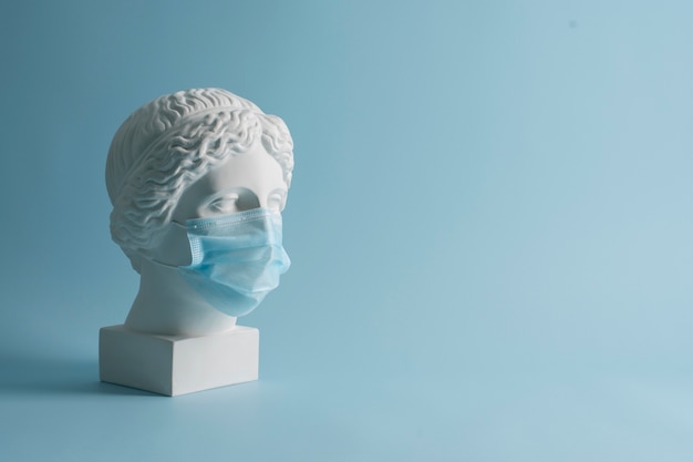 Marmeren sculptuur van historische figuur met medisch masker