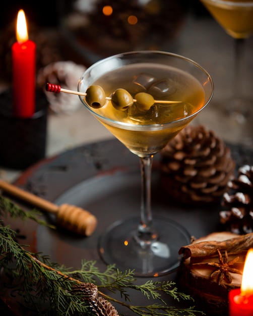 Martini met groene olijven op Kerstmisachtergrond.