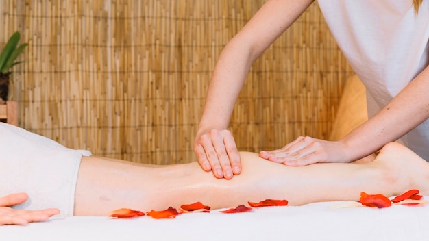 Massageconcept met bloemen naast vrouw