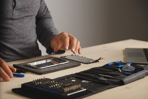 Master is klaar om de telefoon te monteren en te repareren door een nieuwe batterij en scherm te vervangen, zijaanzicht