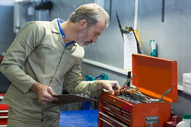 Gratis foto mechanic kijken in toolbox